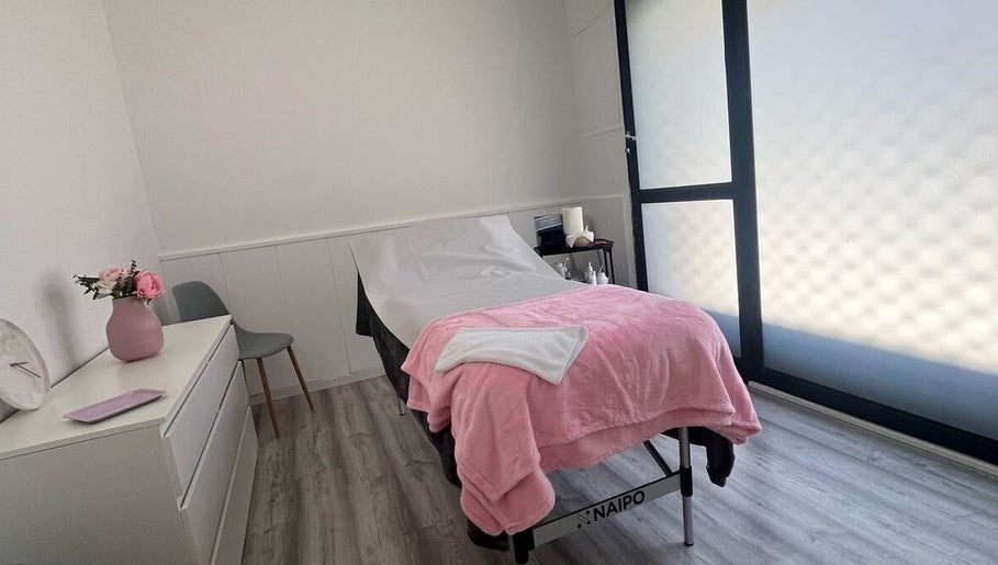 Sala de tratamiento en Beauty Láser, Montornès Del Vallès, Catalunya, ES, con cama cubierta de manta rosa.