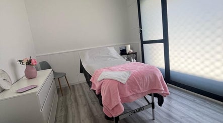 Sala de tratamiento en Beauty Láser, Montornès Del Vallès, Catalunya, ES, con cama cubierta de manta rosa.