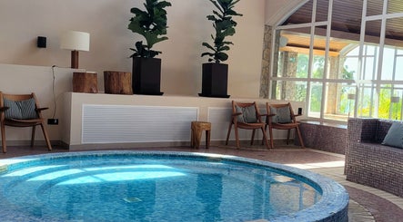 Piscina interior en AUA SPA Zel Costa Brava, TOSSA DE MAR, Catalunya, ES, rodeada de sillas y plantas.