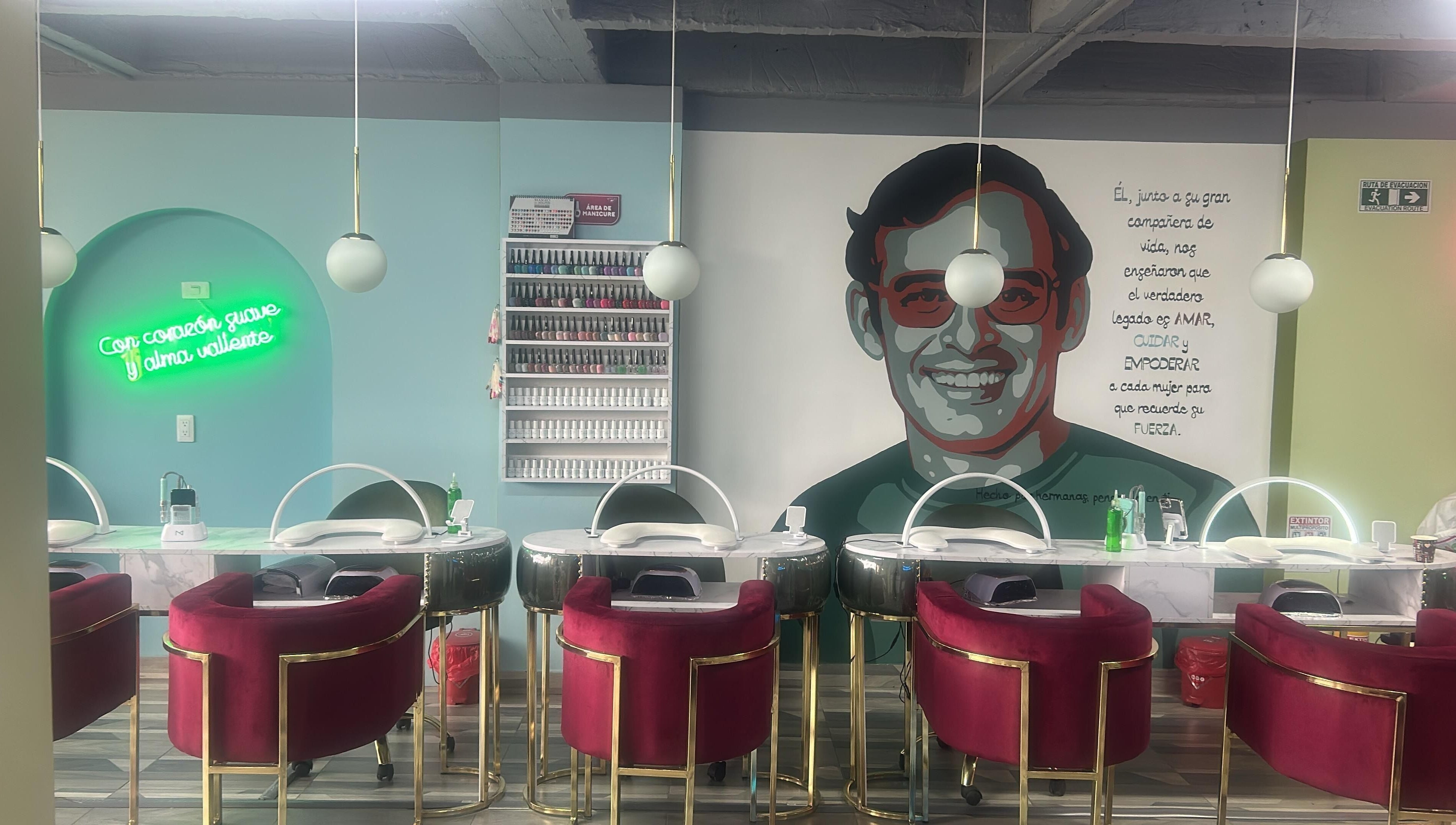 Interior de Rafaelas Nails Spa en Bogotá, Bogotá, CO, con sillones bordó y decoración artística vibrante.