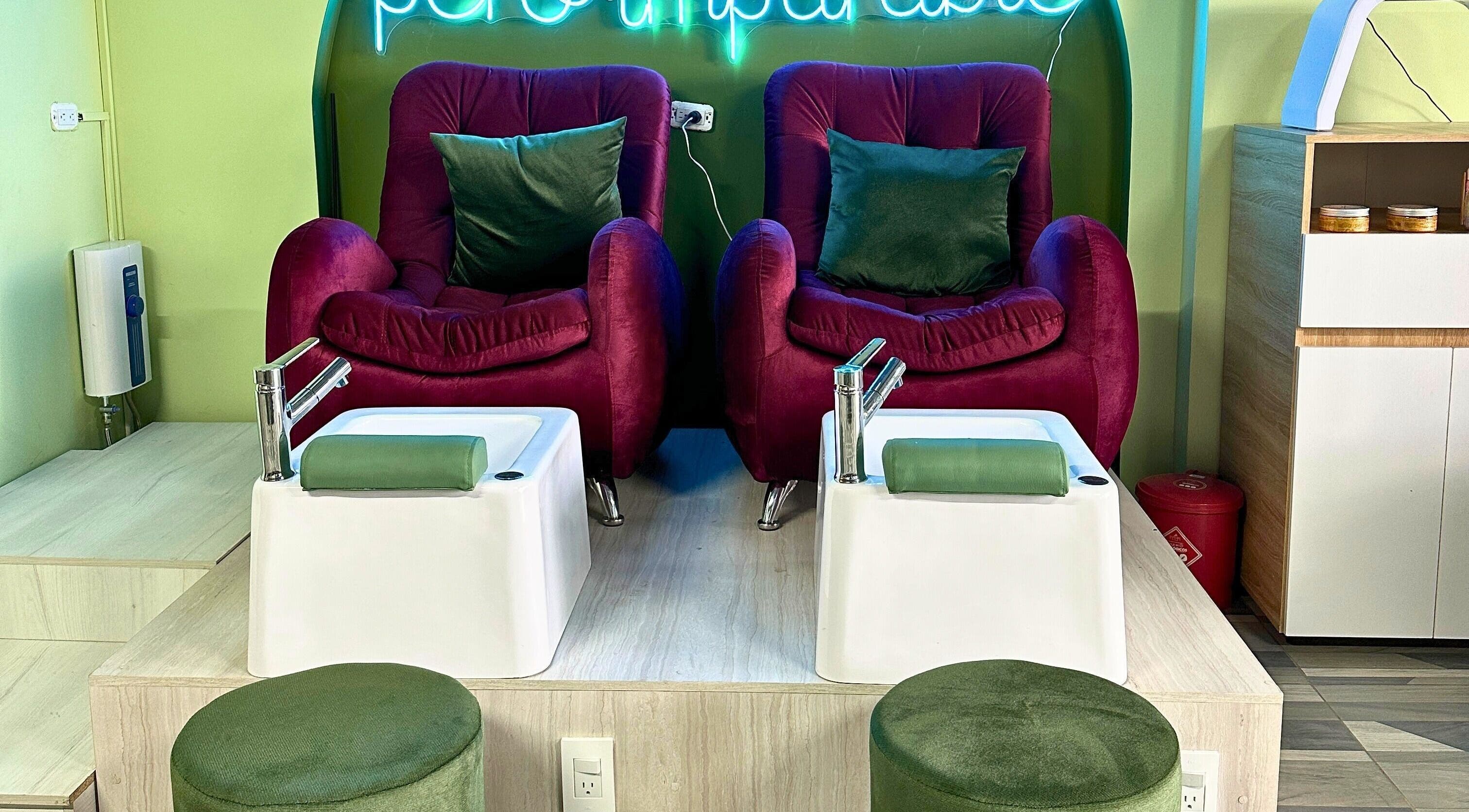 Zona de pedicura de Rafaelas Nails Spa en Bogotá, Bogotá, CO, con sillas aterciopeladas y tinas elegantes.