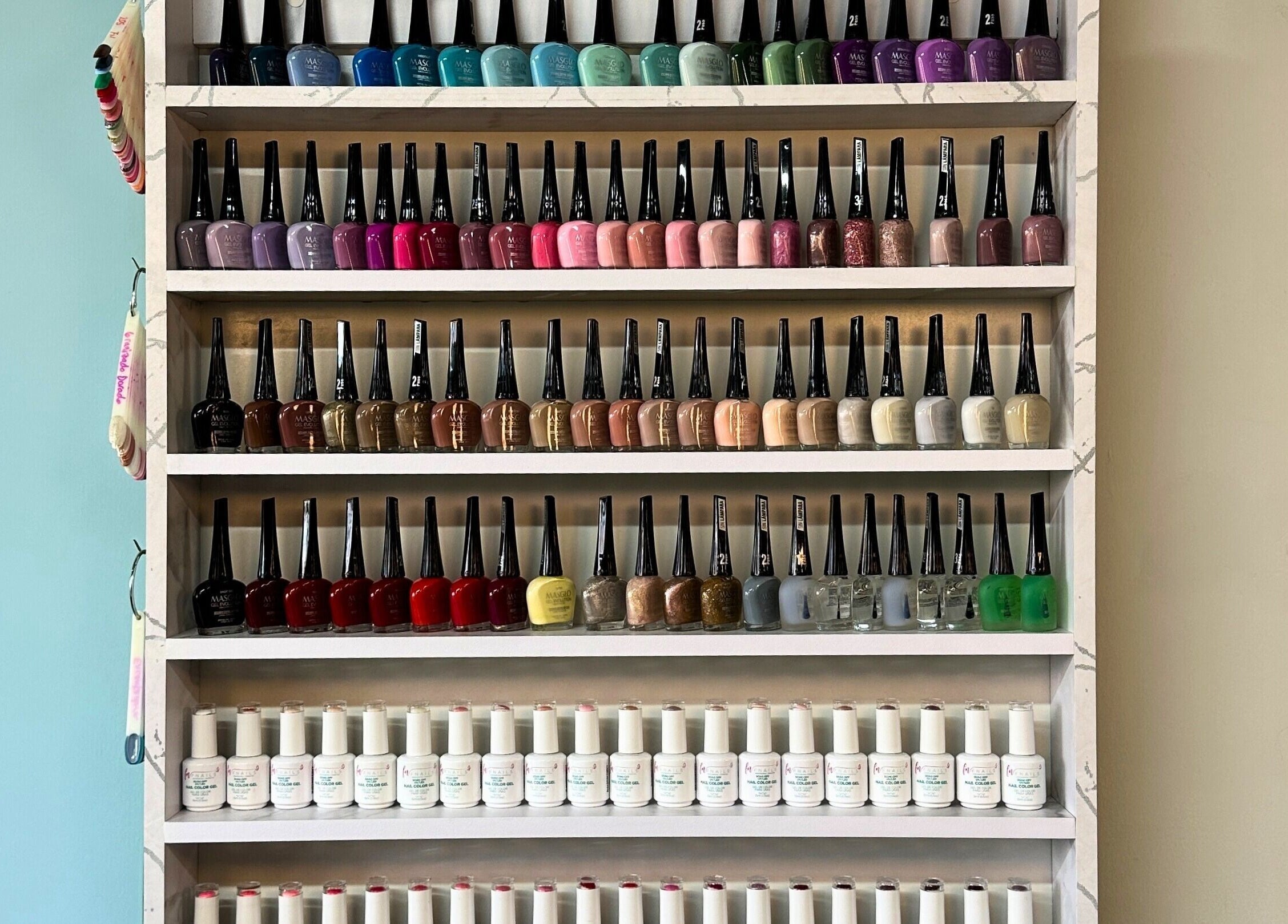 Exhibidor de esmaltes en Rafaelas Nails Spa, Bogotá, Bogotá, CO, mostrando una variedad de colores.