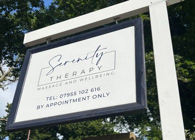 Serenity Therapy - Massage & Wellbeing entrance sign in Bournemouth, England, GB, amidst lush trees.