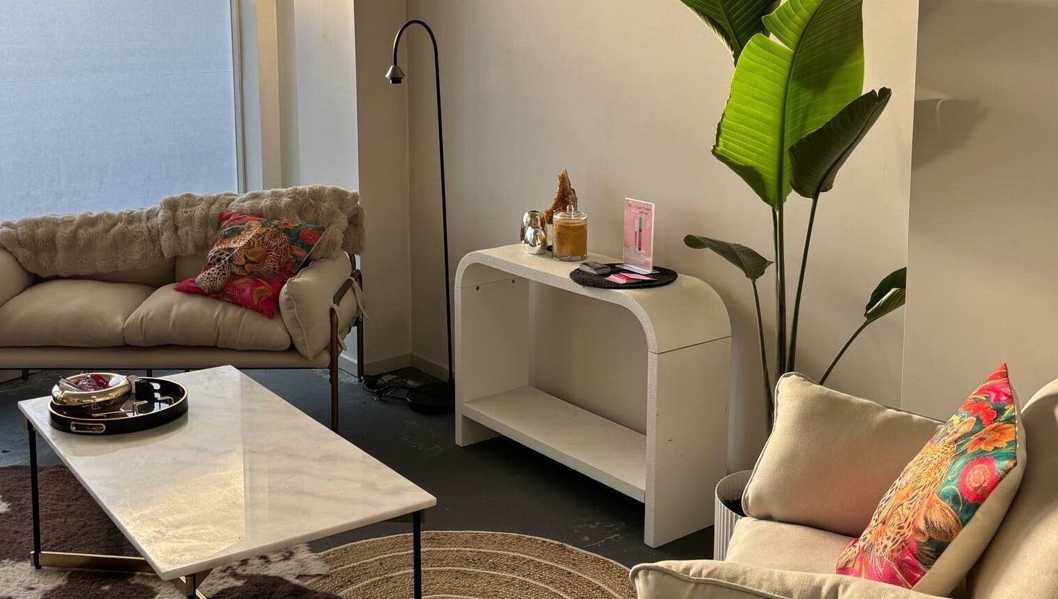 Chic lounge area at Divine Aesthetics in Levin, Manawatū-whanganui Region, NZ, featuring cozy sofas and vibrant decor.