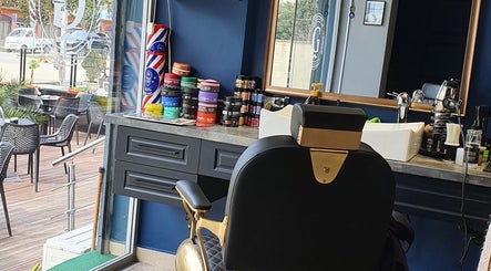Cozy interior of Barber G shop, Durrës County, AL with stylish chair and hair products on display.