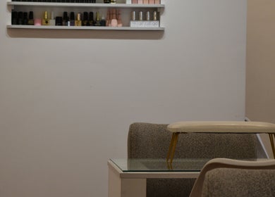 Estación de manicura en Art Beauty, Ciudad De Guatemala, Guatemala, GT, con esmaltes organizados en estante.
