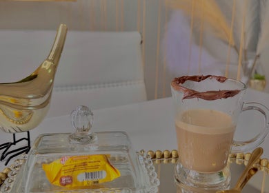 Café elegante no Nicole Charão Beauty & Clinic, Rio Grande Do Sul, BR, ao lado de decoração dourada.