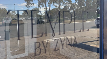 Reflection of Temple by Zyna signage on window in Moranbah, Queensland, AU.