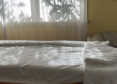 Tranquil massage table at Humm Massage, Sawtell/Coffs Harbour, New South Wales, AU with sunlight filtering through curtains.