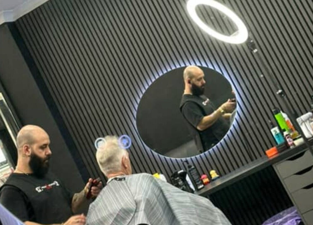 Stylist at Awesome Barbers in Melbourne, Victoria, AU, works with a client in a sleek, modern setting.