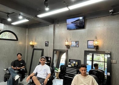 Cozy interior of Barbershop AK-15, Nusa Tenggara Barat, ID, featuring customers and modern decor.