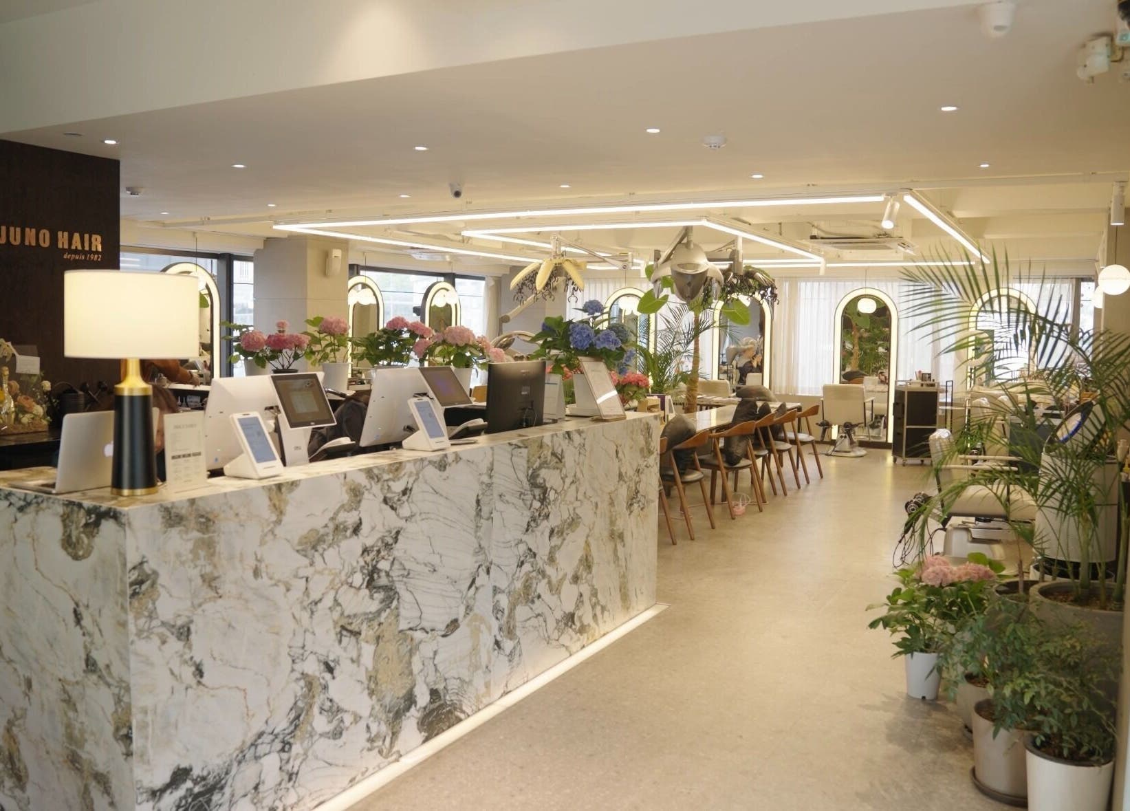 Chic interior of Juno Hair Apgujeong Rodeo branch in Seoul, South Korea, showcasing modern decor and warm ambiance.