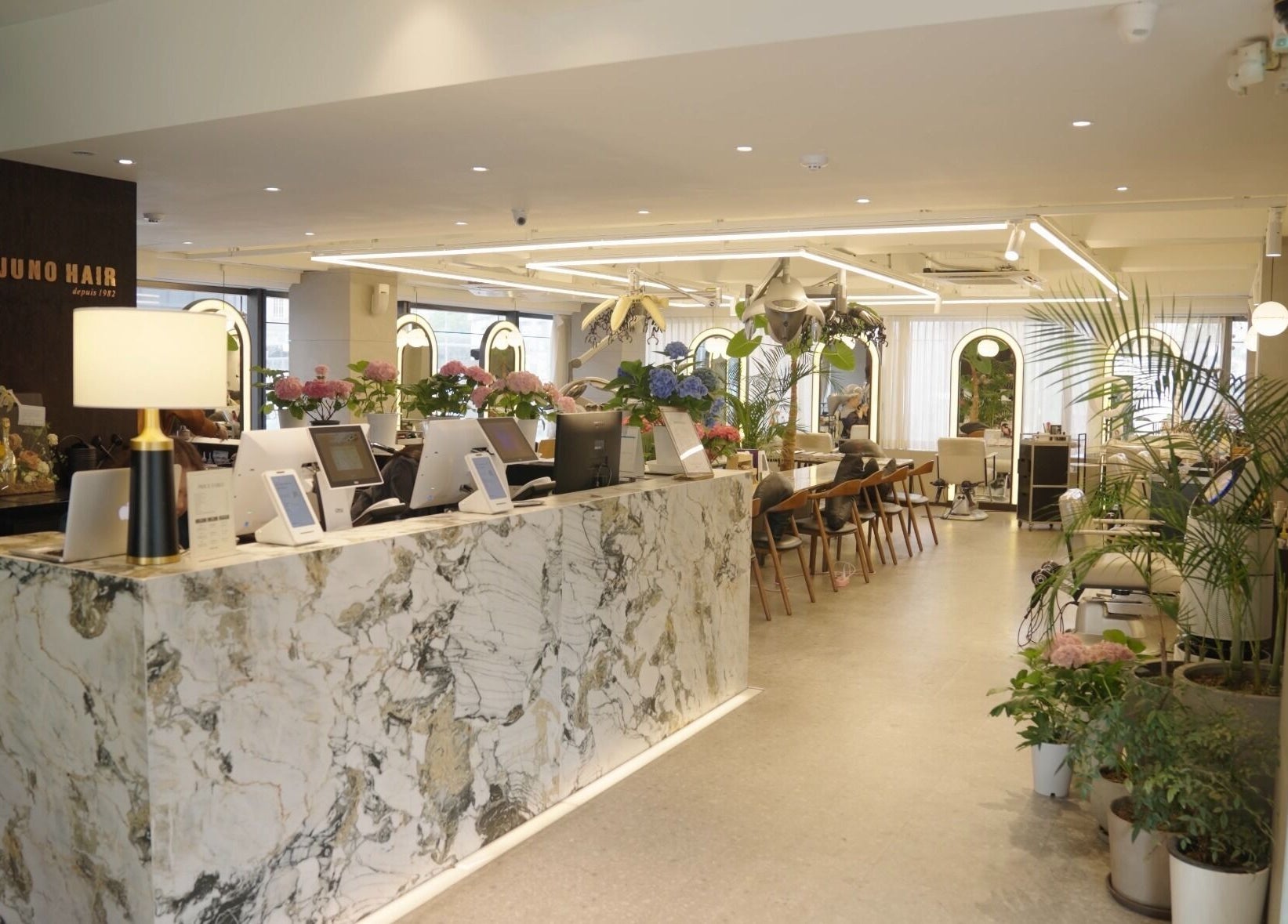 Chic interior of Juno Hair Apgujeong Rodeo branch in Seoul, South Korea, showcasing modern decor and warm ambiance.