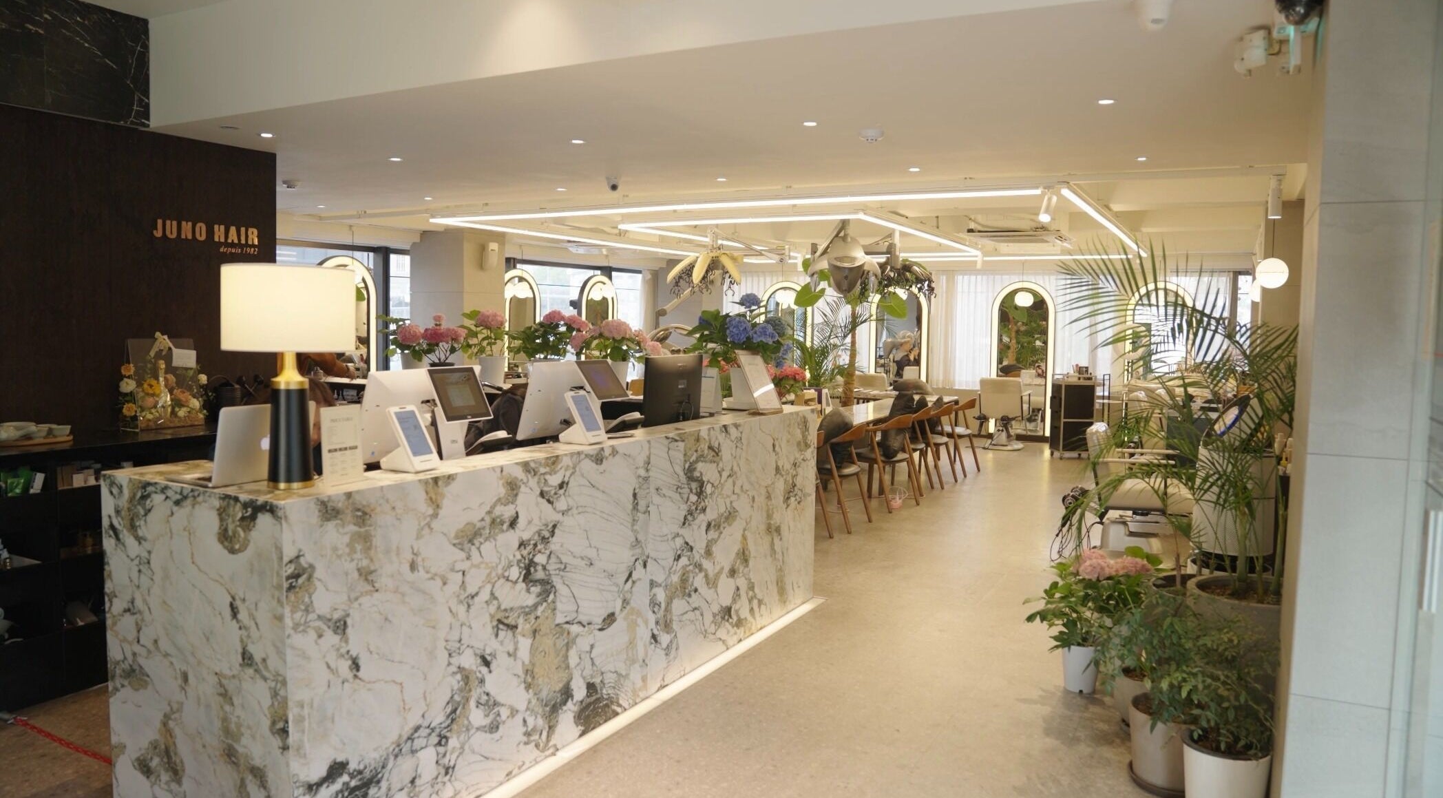 Chic interior of Juno Hair Apgujeong Rodeo branch in Seoul, South Korea, showcasing modern decor and warm ambiance.