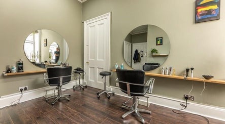 Contemporary salon interior at Scott’s Hairdressing, Glasgow, Scotland, GB with chic mirrors and styling chairs.