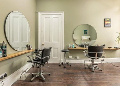 Chic interior of Scott’s Hairdressing in Glasgow, Scotland, GB featuring modern styling chairs and mirrors.
