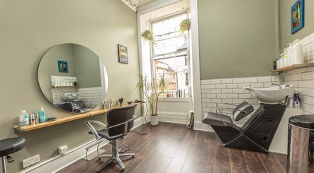 Interior of Scott’s Hairdressing in Glasgow, Scotland, GB, featuring a stylish workstation and washing area.