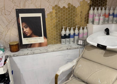 Hijabi Hair salon's curl care station in Bristol, England, GB, featuring products and a wash basin.