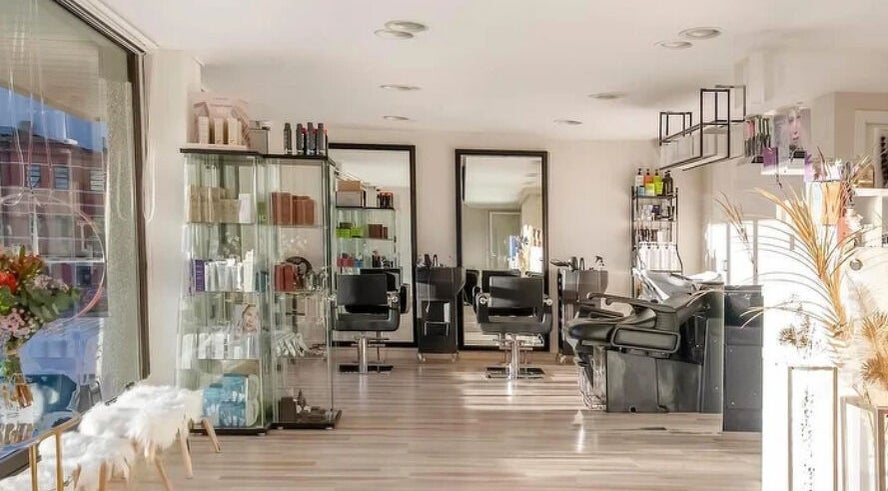Interior moderno de Silva Beauty en A Coruña, ES con sillas y estanterías de productos de belleza.