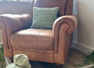 Luxurious leather armchair with a green cushion at Sophie’s Ultimate Beauty, Deeping Saint James, England, GB.