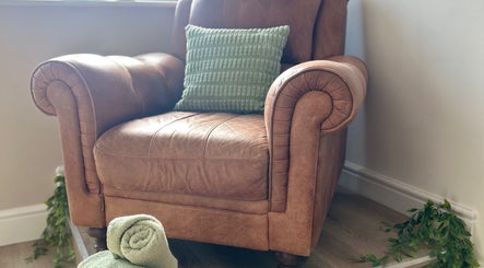 Luxurious leather armchair with a green cushion at Sophie’s Ultimate Beauty, Deeping Saint James, England, GB.