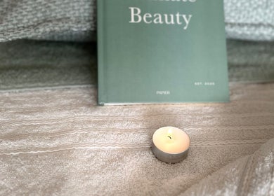Cozy setup with a lit candle and beauty book at Sophie's Ultimate Beauty, Deeping Saint James, England, GB.