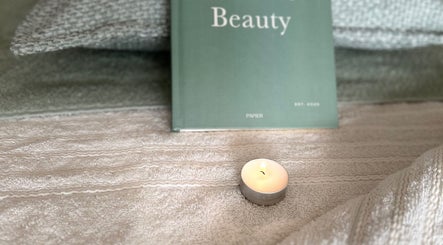 Cozy setup with a lit candle and beauty book at Sophie's Ultimate Beauty, Deeping Saint James, England, GB.