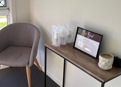 JH Beauty lobby in Upper Caboolture, Queensland, AU with chair, product display, and certificate.