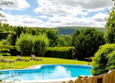 Relax by the pool at Peterstone Court Country House & Spa, Llanhamlach, Wales, GB, with lush greenery views.