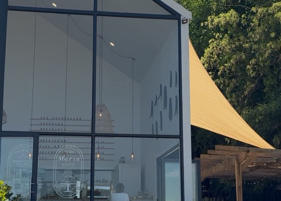 Glass façade of Rovel Beauty Studio Rayton in Rayton, Gauteng, ZA with green surroundings.