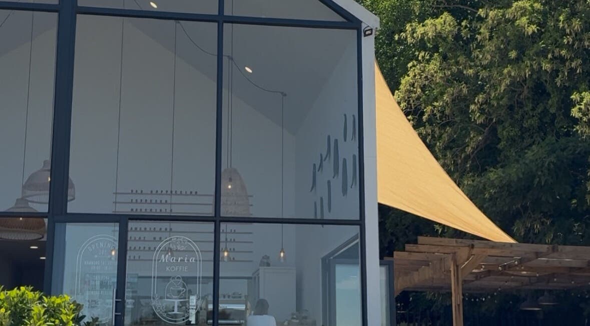 Glass façade of Rovel Beauty Studio Rayton in Rayton, Gauteng, ZA with green surroundings.