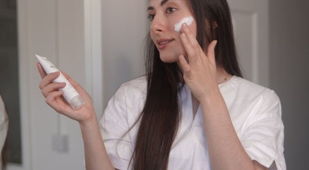 Woman applying face cream at Nonna Skincare, Dublin, County Dublin, IE for a radiant look.