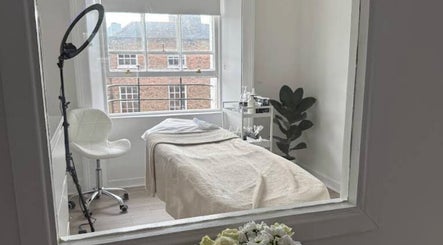 Cozy treatment space at Nonna Skincare in Dublin, County Dublin, IE featuring a plush bed and vibrant lighting.