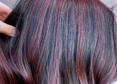 Vibrant pink and black hair highlights at Divine Beauty Parlor, San Antonio, Texas, US.