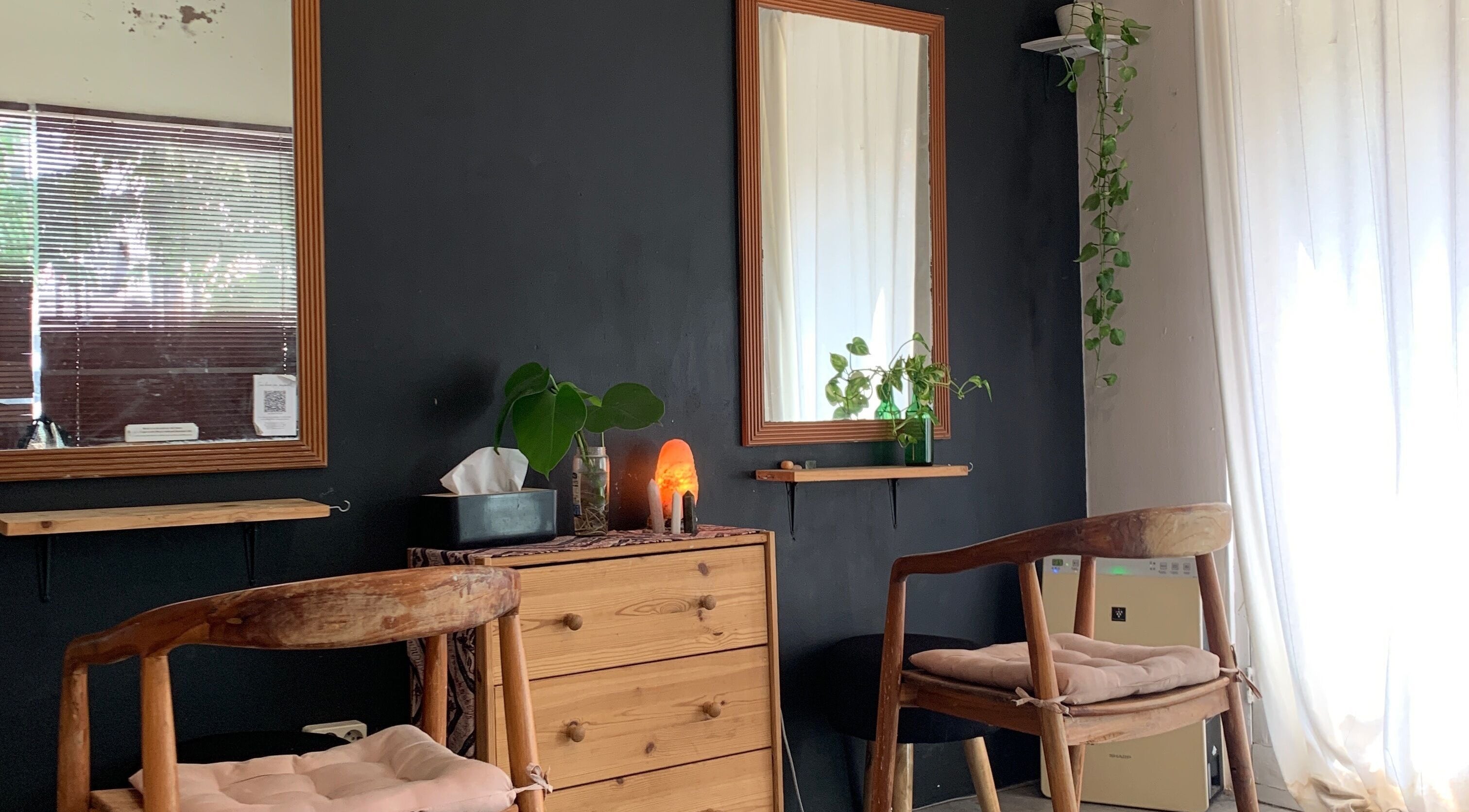 Cozy interior of Moonstone Hair Studio with wooden chairs and mirrors, Jakarta, ID.