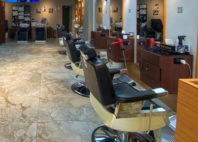 Modern salon at The Comb Salon, Cairo Governorate, EG featuring sleek chairs and elegant decor.