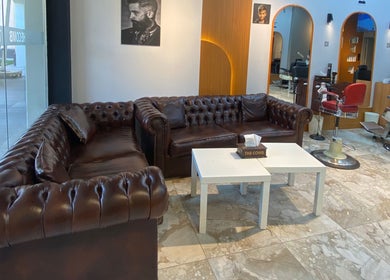 Luxurious leather sofas at The Comb Salon in Cairo Governorate, Cairo Governorate, EG offer a welcoming atmosphere.
