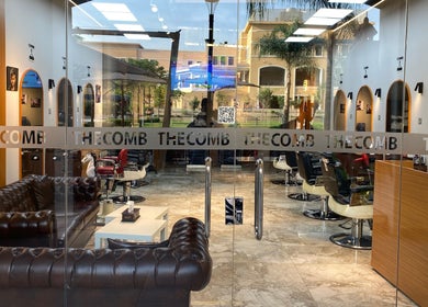 Spacious interior of The Comb Salon in Cairo Governorate, Egypt, featuring stylish leather seating and modern decor.