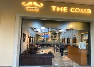 Front view of The Comb Salon in Cairo Governorate, EG, showcasing luxe interiors and stylish signage.