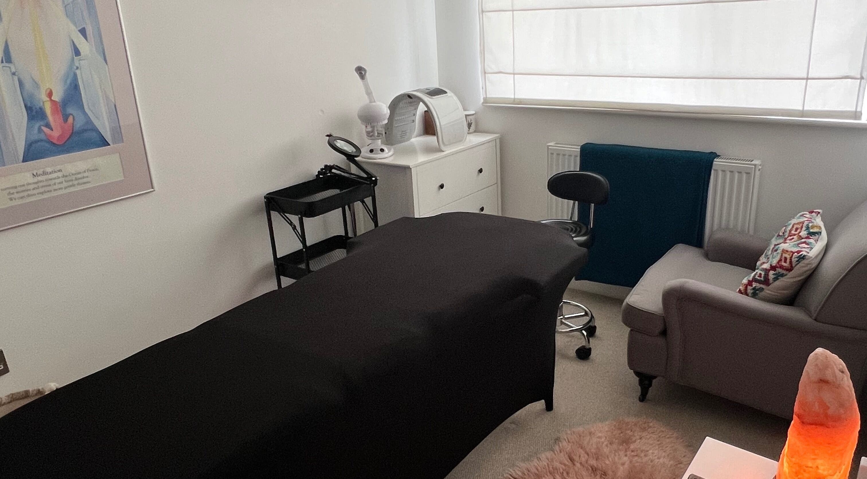 Cozy treatment room at Face Spa in Hastings, England, GB featuring a massage table and relaxing decor.