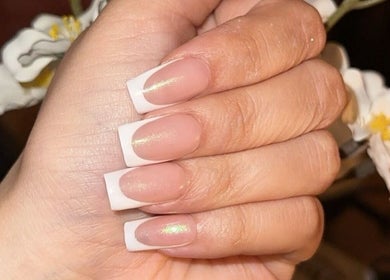 French manicured hand from Klaw Cartel in Birmingham, England, GB against a floral background.