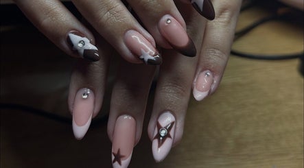 Elegant nail art with star designs at Klaw Cartel, Birmingham, England, GB on a wooden surface.
