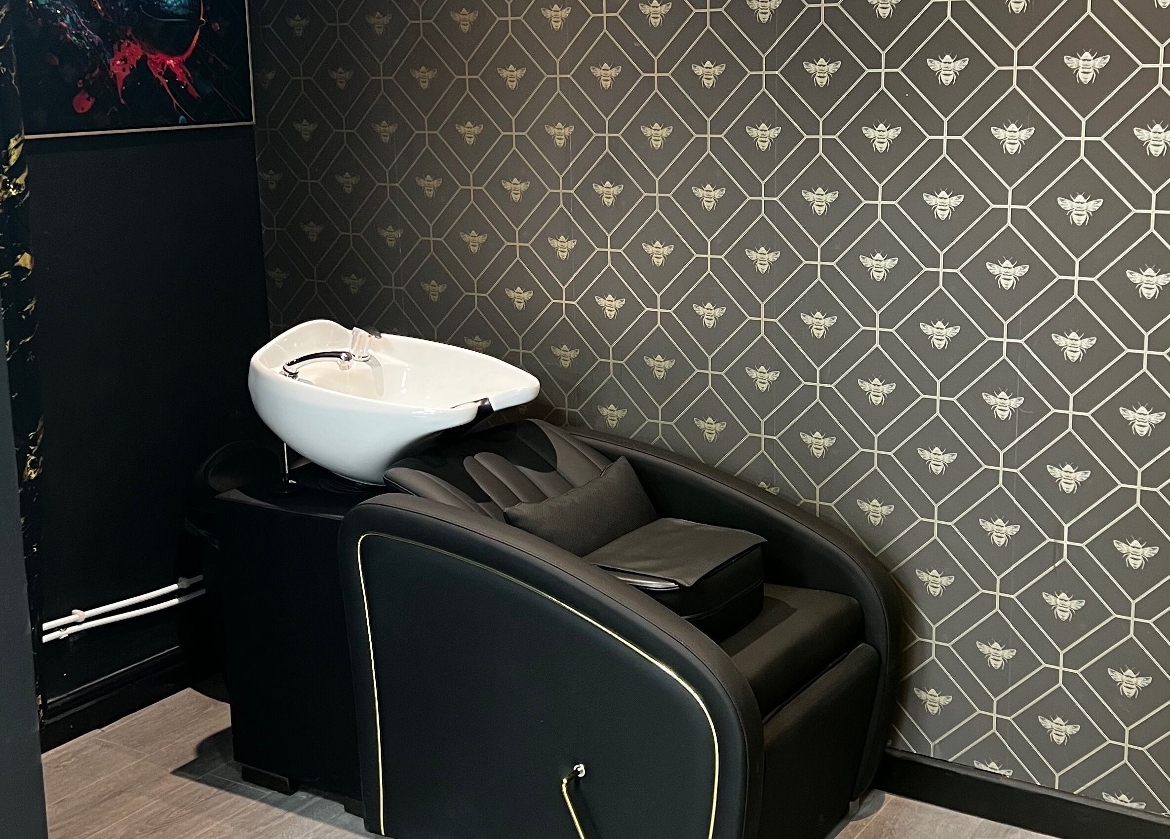 Elegant wash station at MMS Mattys Mane Studio, Stockport, England, GB features plush seating and bee-patterned wall.