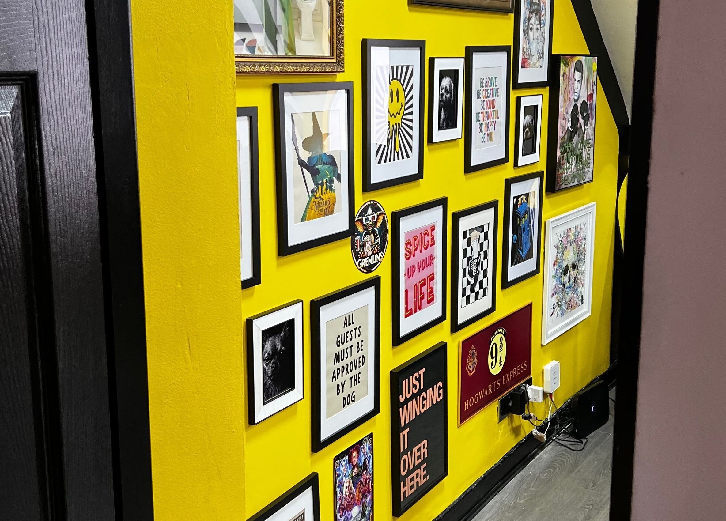 Colorful framed art on yellow wall at MMS Mattys Mane Studio, Stockport, England, GB enhancing creativity.