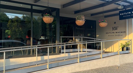 Front view of Kaitlyn Wagner Hairdressing in Hawthorne, Queensland, AU with sleek design and hanging plants.