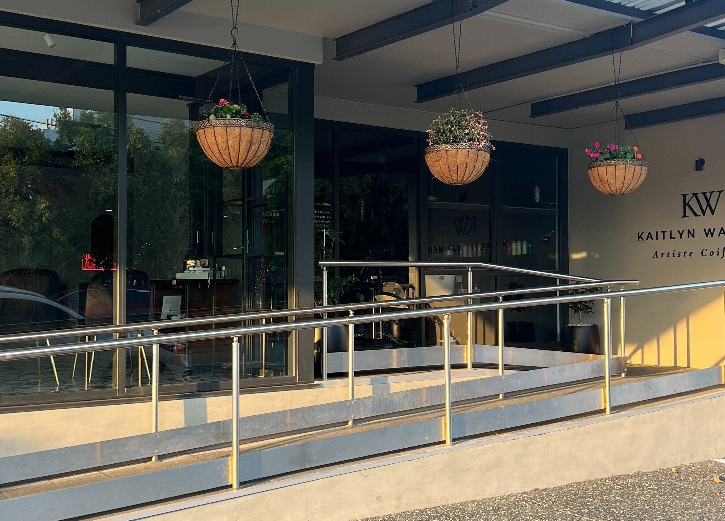 Kaitlyn Wagner Hairdressing entrance with hanging baskets in Hawthorne, Queensland, AU.
