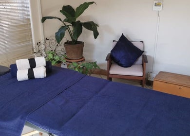 Relaxing massage room at Fellas Grooming Horison, Roodepoort, Gauteng, ZA featuring a bed and greenery.