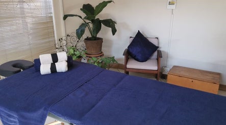 Relaxing massage room at Fellas Grooming Horison, Roodepoort, Gauteng, ZA featuring a bed and greenery.