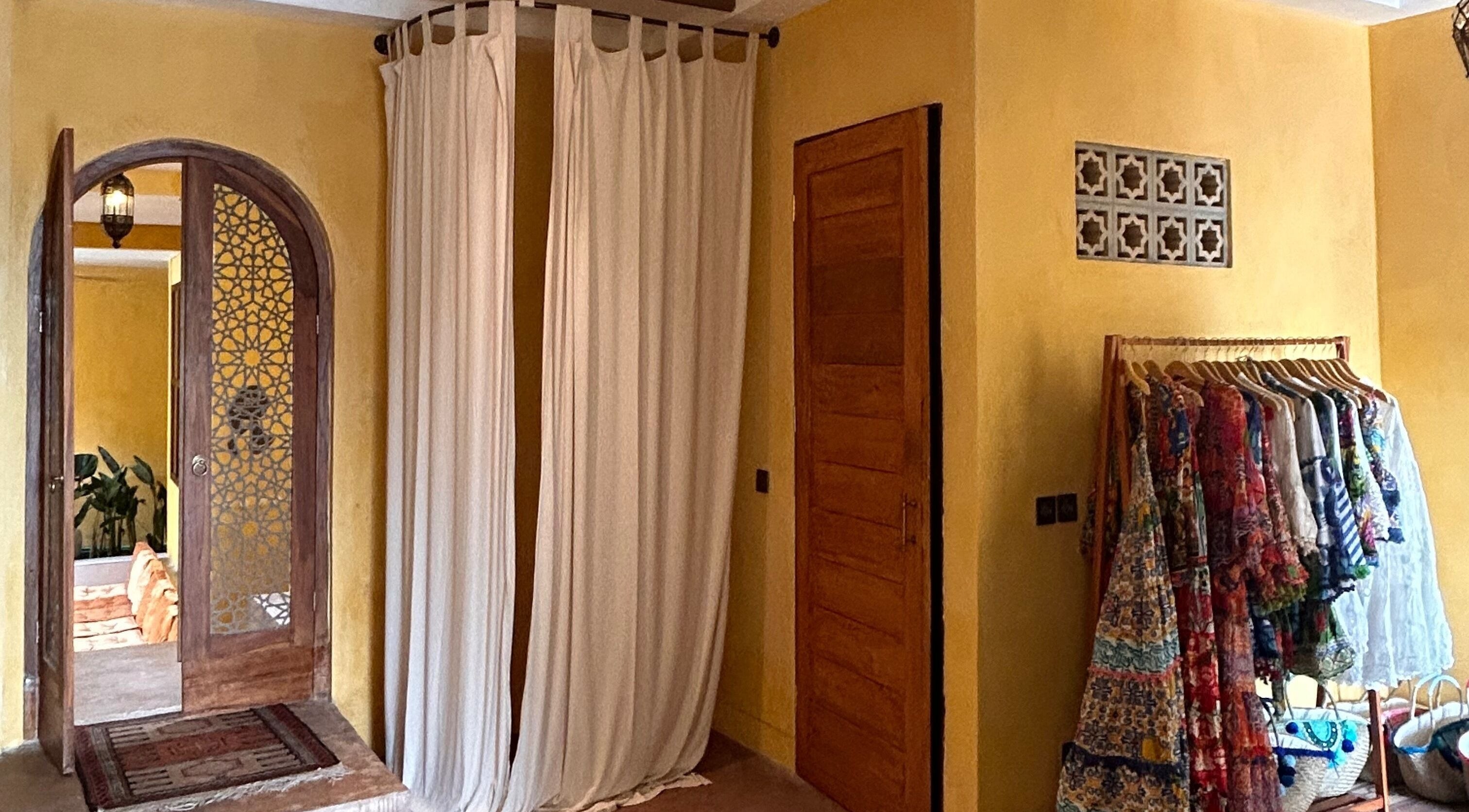 Entrance with ornate wooden door and colorful gowns at Limu Spa Moroccan, Bali, Bali, ID.