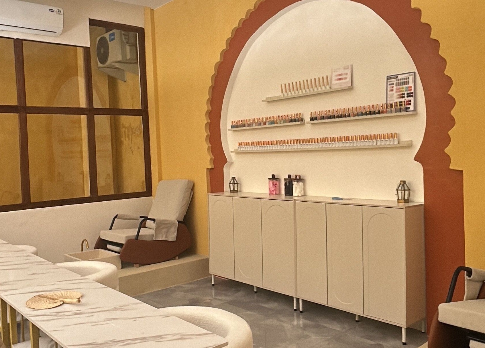 Relaxing seating area at Limu Spa Moroccan in Bali, Bali, ID with a Moroccan arch and nail polish display.